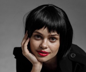Young woman with red lipstick and a sleek black bob hairstyle